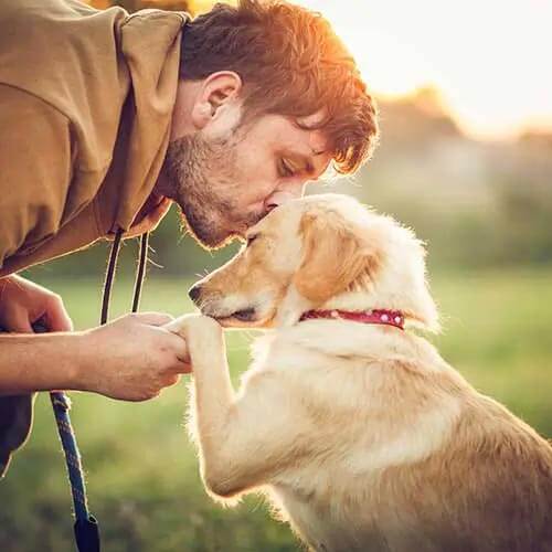 A man kissing his puppy